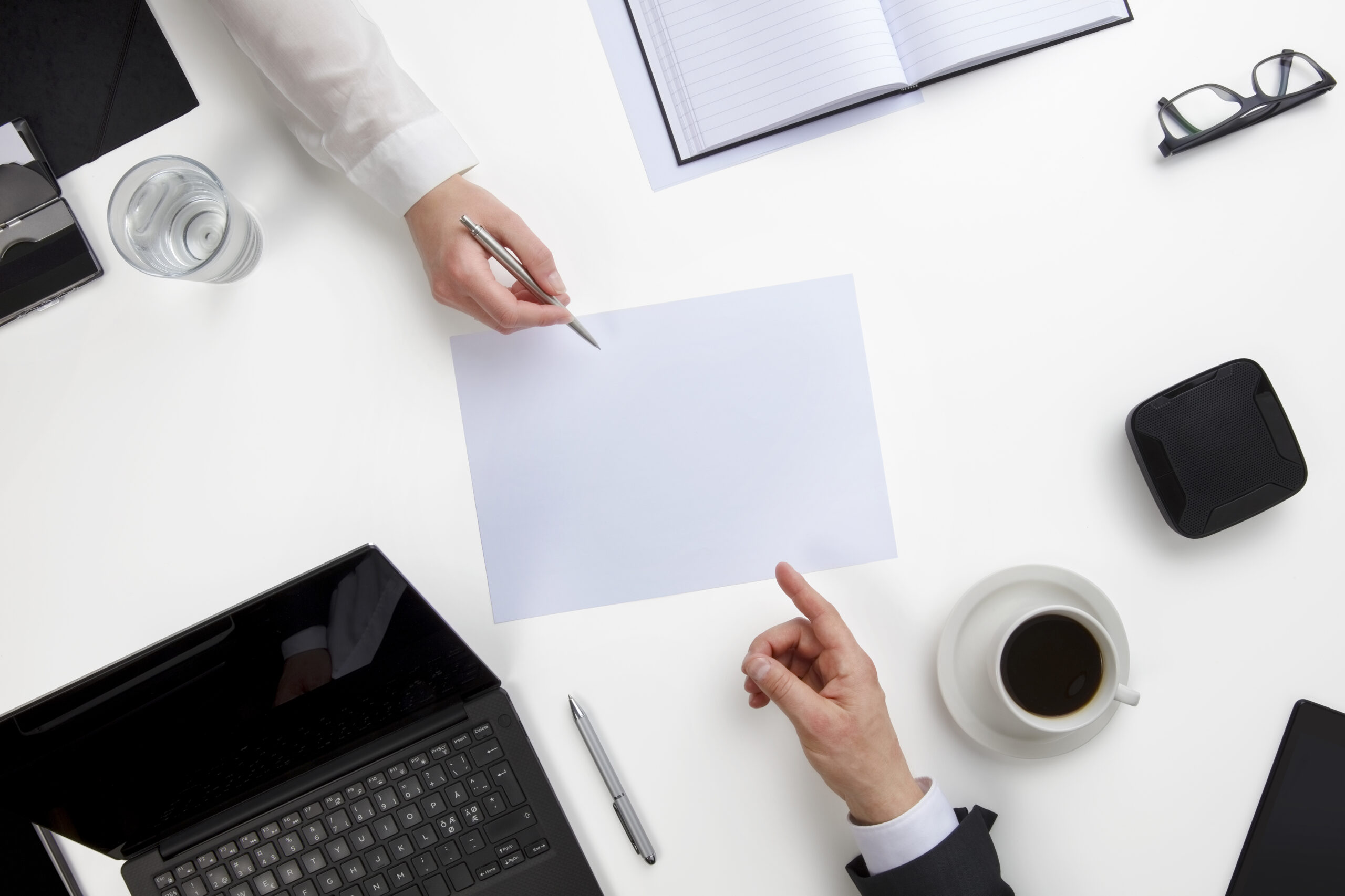 Business People Discussing Over Document At White Desk
